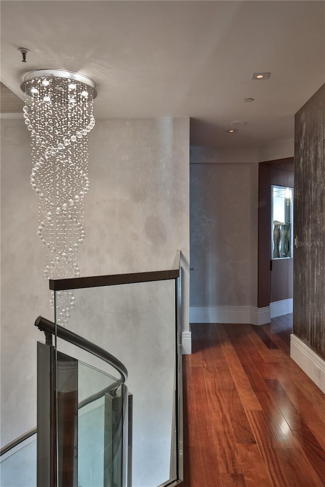 hallway featuring hardwood / wood-style floors and an inviting chandelier