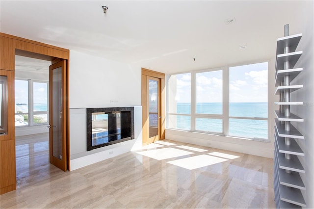 unfurnished living room featuring a water view