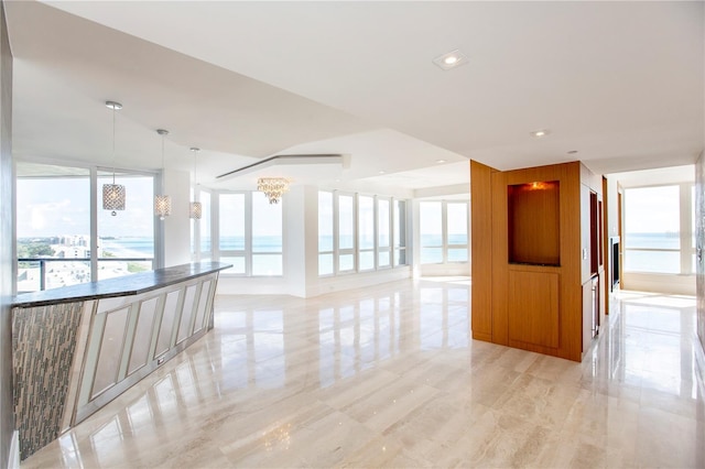 spare room with a notable chandelier and a water view