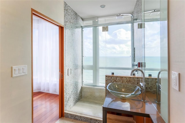 bathroom featuring hardwood / wood-style floors, plenty of natural light, and a water view