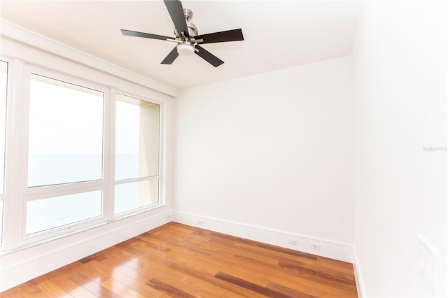 spare room with wood-type flooring, a wealth of natural light, and ceiling fan