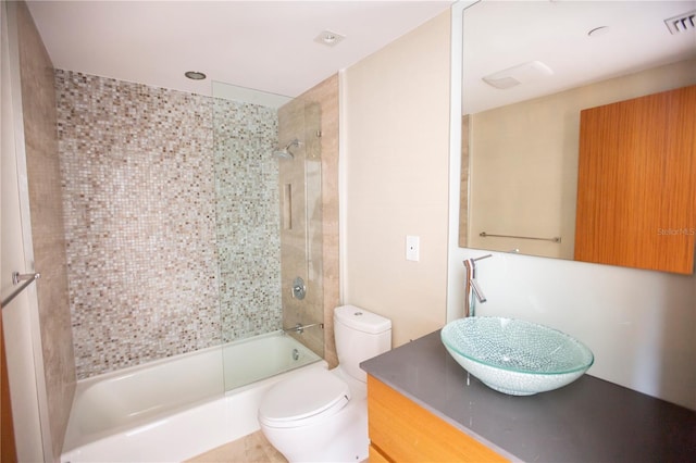 full bathroom with vanity, tiled shower / bath combo, and toilet