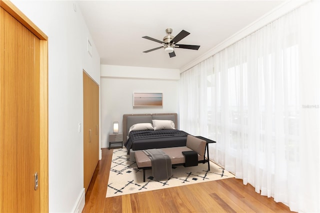 bedroom featuring ceiling fan, a closet, and light hardwood / wood-style flooring