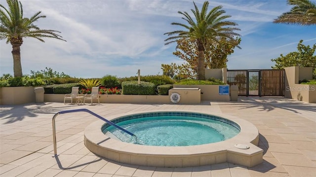 view of pool with a hot tub and a patio area