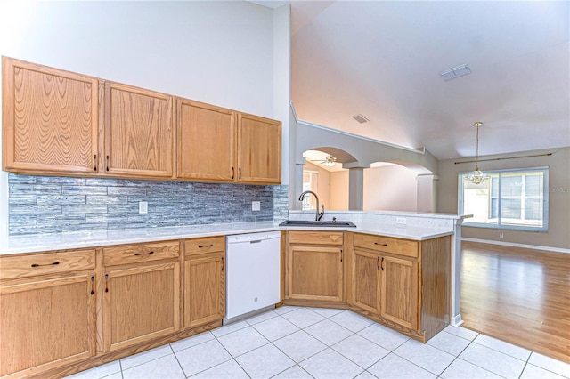 kitchen with tasteful backsplash, sink, light tile patterned floors, decorative light fixtures, and dishwasher