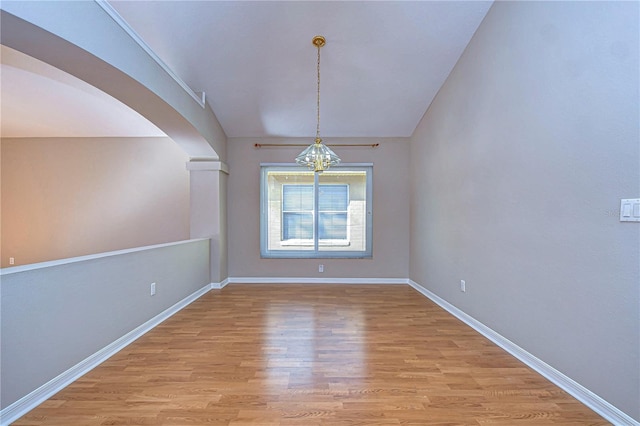 unfurnished dining area with a notable chandelier and light hardwood / wood-style floors