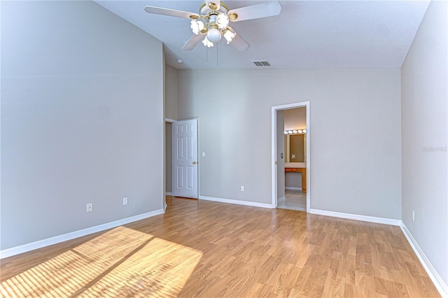 unfurnished bedroom featuring ceiling fan, light wood-type flooring, connected bathroom, and lofted ceiling