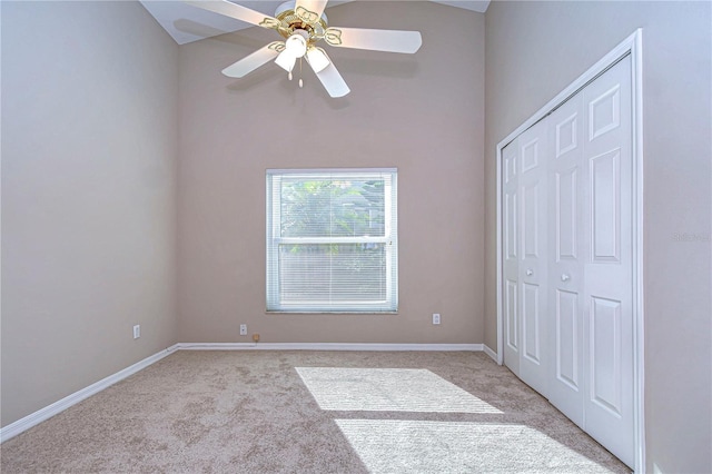 unfurnished bedroom with ceiling fan, a closet, light carpet, and vaulted ceiling