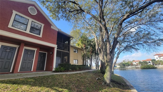 exterior space with a water view and stucco siding