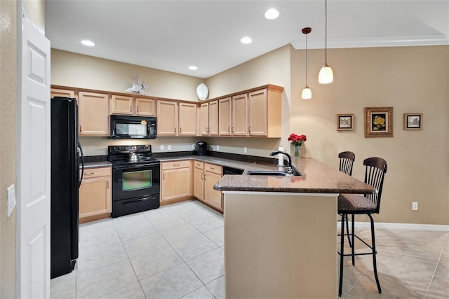 kitchen featuring black appliances, a kitchen breakfast bar, sink, hanging light fixtures, and kitchen peninsula