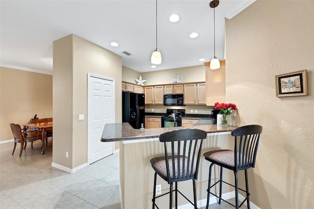 kitchen with kitchen peninsula, pendant lighting, a breakfast bar area, light brown cabinetry, and black appliances