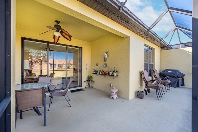 view of patio featuring a lanai, area for grilling, and ceiling fan