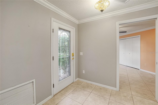 tiled foyer entrance featuring a textured ceiling and crown molding