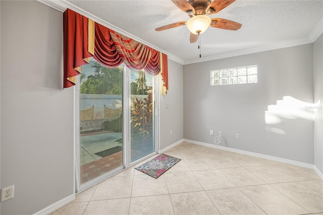 tiled empty room with a textured ceiling, a wealth of natural light, ornamental molding, and ceiling fan