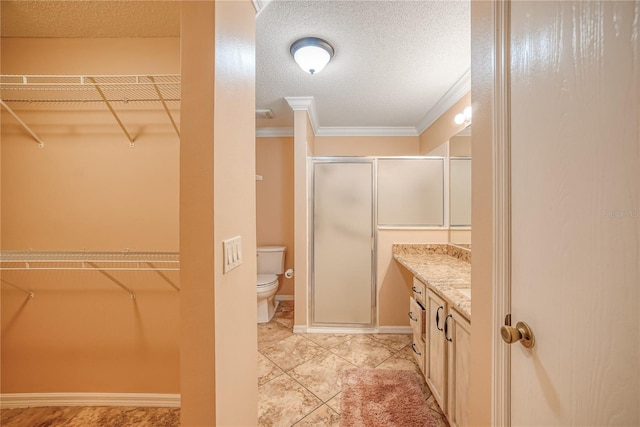 bathroom featuring vanity, a shower with door, tile patterned floors, toilet, and ornamental molding