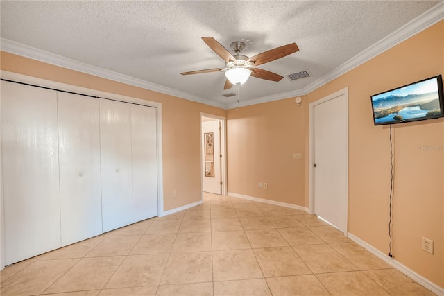 unfurnished bedroom featuring a textured ceiling, ceiling fan, light tile patterned flooring, and crown molding