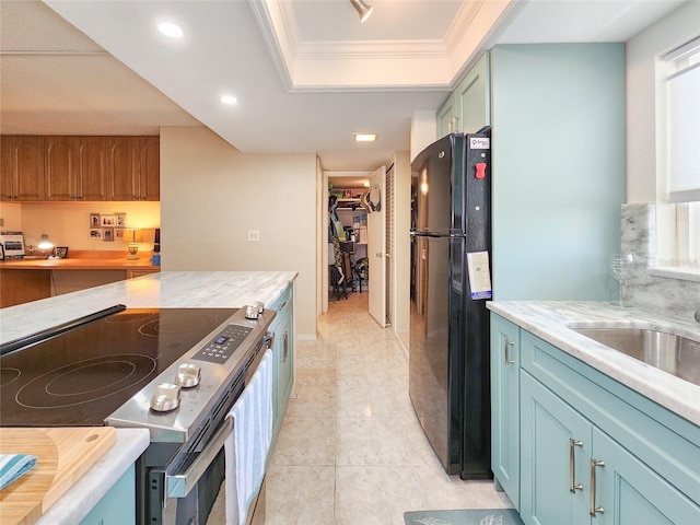 kitchen with stainless steel electric range, black refrigerator, crown molding, a wealth of natural light, and a tray ceiling