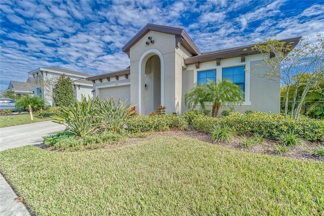 mediterranean / spanish-style home featuring a front yard and a garage