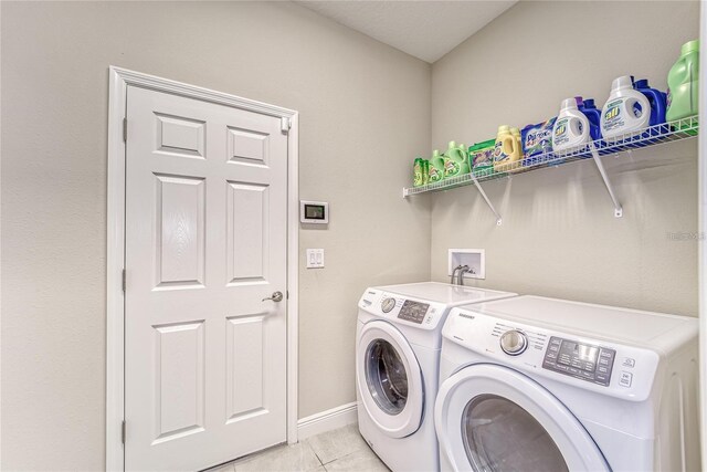 clothes washing area featuring light tile patterned floors and washing machine and dryer