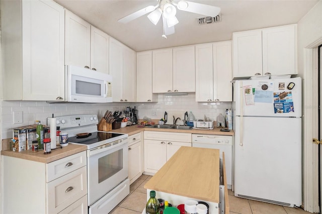 kitchen with white appliances, decorative backsplash, and white cabinets