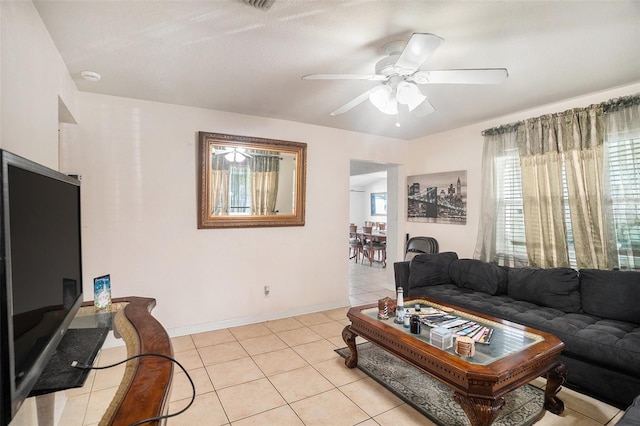 living room featuring a healthy amount of sunlight, light tile patterned floors, and ceiling fan