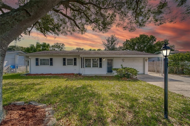 ranch-style house featuring a lawn and a garage