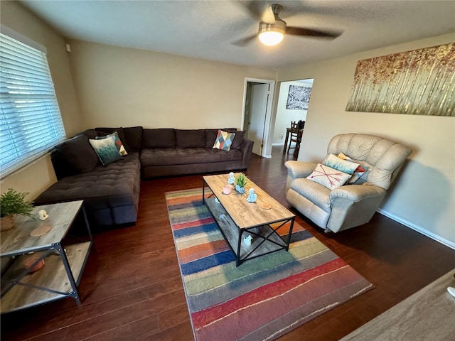 living room with ceiling fan and dark wood-type flooring