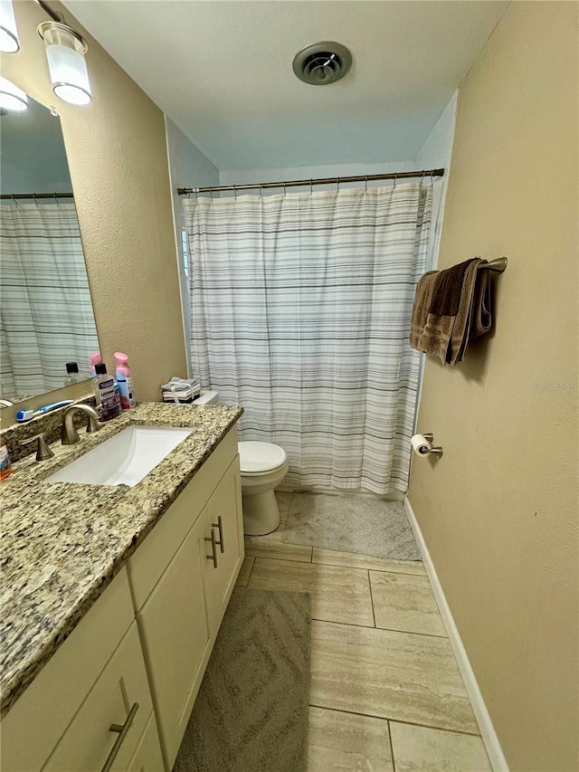 bathroom with tile patterned flooring, vanity, and toilet