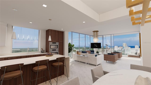 kitchen with a kitchen breakfast bar, white cabinetry, hanging light fixtures, and double oven