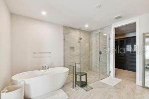 bathroom featuring shower with separate bathtub