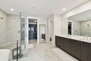 bathroom with vanity, tile walls, and shower with separate bathtub