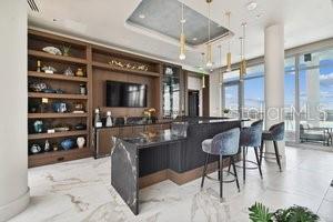 bar with a tray ceiling, floor to ceiling windows, and built in features