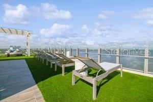 dock area with a yard, a pergola, and a water view