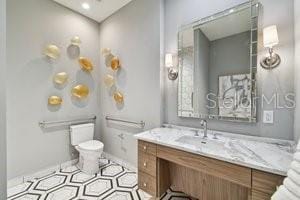 bathroom featuring tile patterned flooring, vanity, and toilet