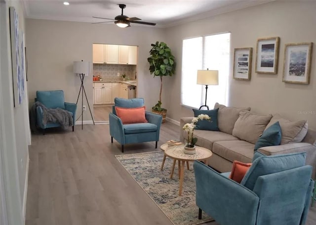 living room featuring light hardwood / wood-style floors, ceiling fan, and crown molding