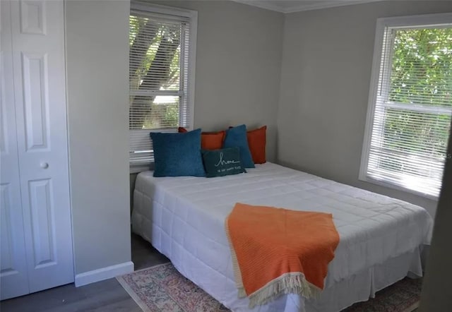 bedroom with dark hardwood / wood-style floors, multiple windows, and crown molding