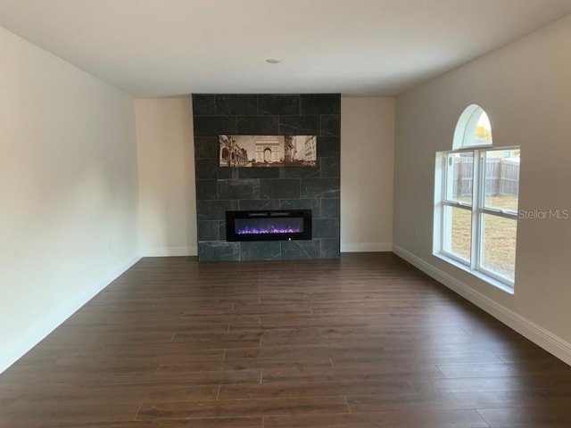 unfurnished living room featuring dark hardwood / wood-style floors and a tile fireplace