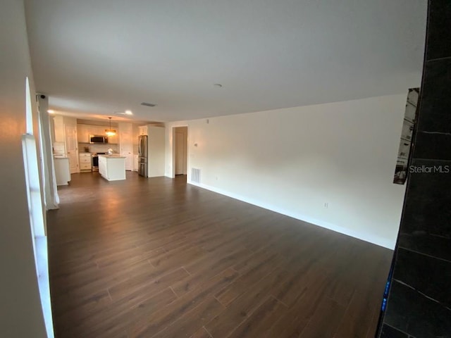 unfurnished living room with dark hardwood / wood-style flooring