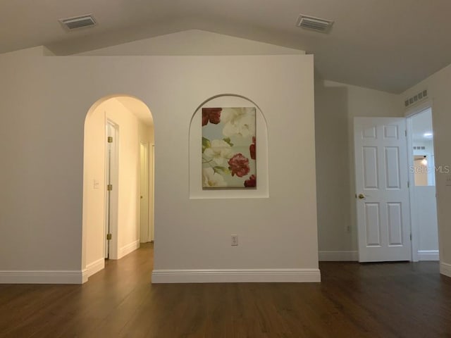 unfurnished room featuring dark hardwood / wood-style floors and lofted ceiling