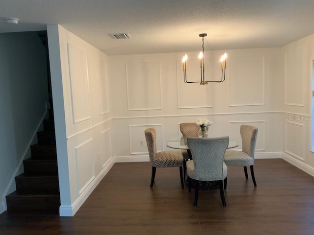 dining area featuring dark hardwood / wood-style flooring and a notable chandelier