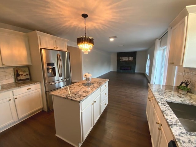 kitchen featuring white cabinetry, tasteful backsplash, decorative light fixtures, a kitchen island, and stainless steel fridge with ice dispenser