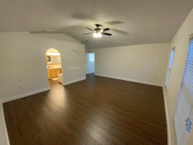 unfurnished living room featuring dark hardwood / wood-style floors, ceiling fan, and vaulted ceiling