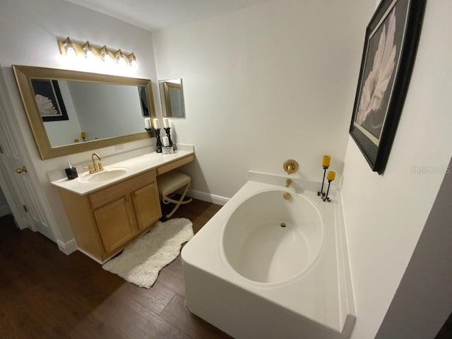 bathroom with wood-type flooring, vanity, and a bathtub