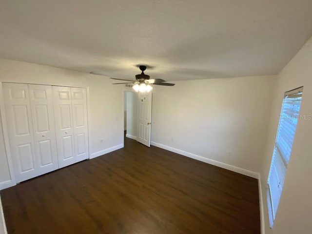 unfurnished bedroom featuring dark hardwood / wood-style flooring, a closet, and ceiling fan