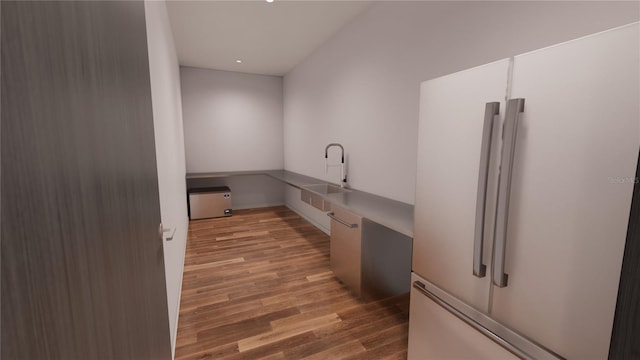 kitchen with sink, built in desk, white fridge, hardwood / wood-style floors, and white cabinets