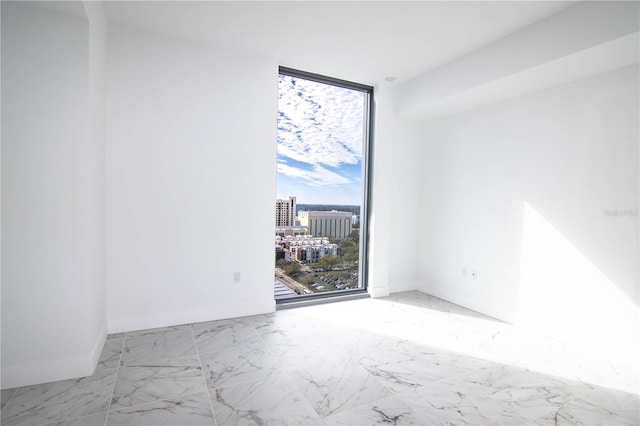 empty room featuring expansive windows and a healthy amount of sunlight