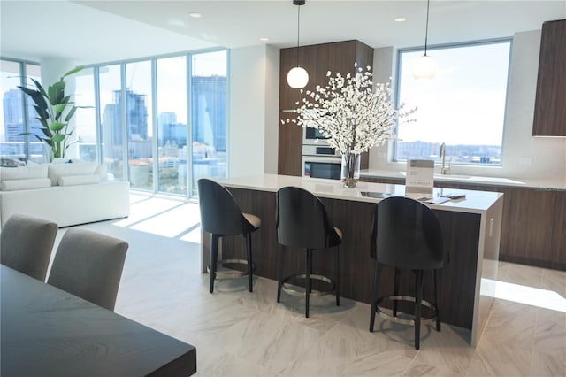 kitchen with a kitchen island, plenty of natural light, a breakfast bar area, and decorative light fixtures