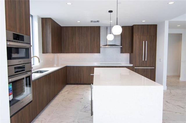 kitchen featuring decorative light fixtures, sink, a center island, black electric cooktop, and wall chimney exhaust hood