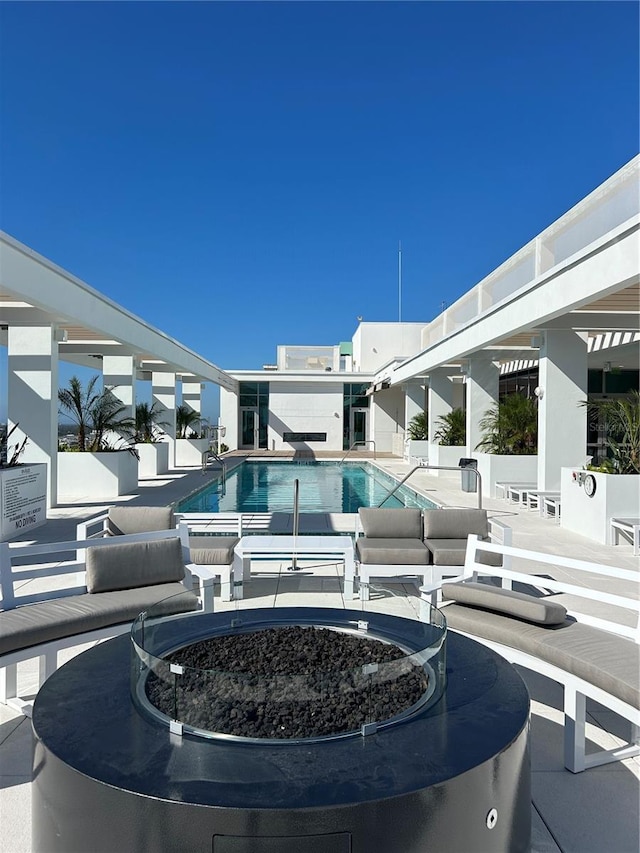 view of swimming pool with a patio area and an outdoor fire pit