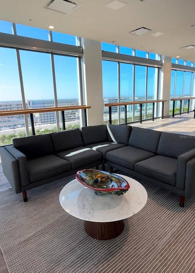 living room featuring a water view, a wealth of natural light, and a wall of windows